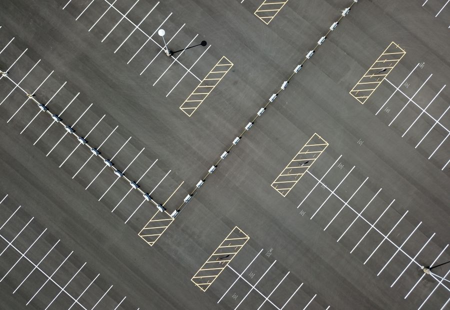 Overhead view of a freshly paved parking lot with new white stall striping